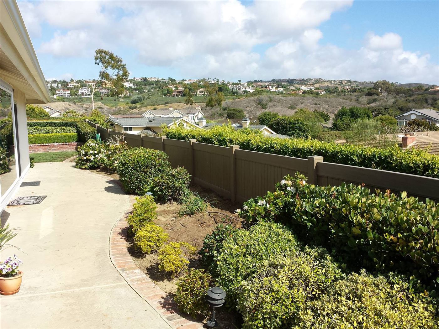 Tall vinyl privacy fence with hillside view