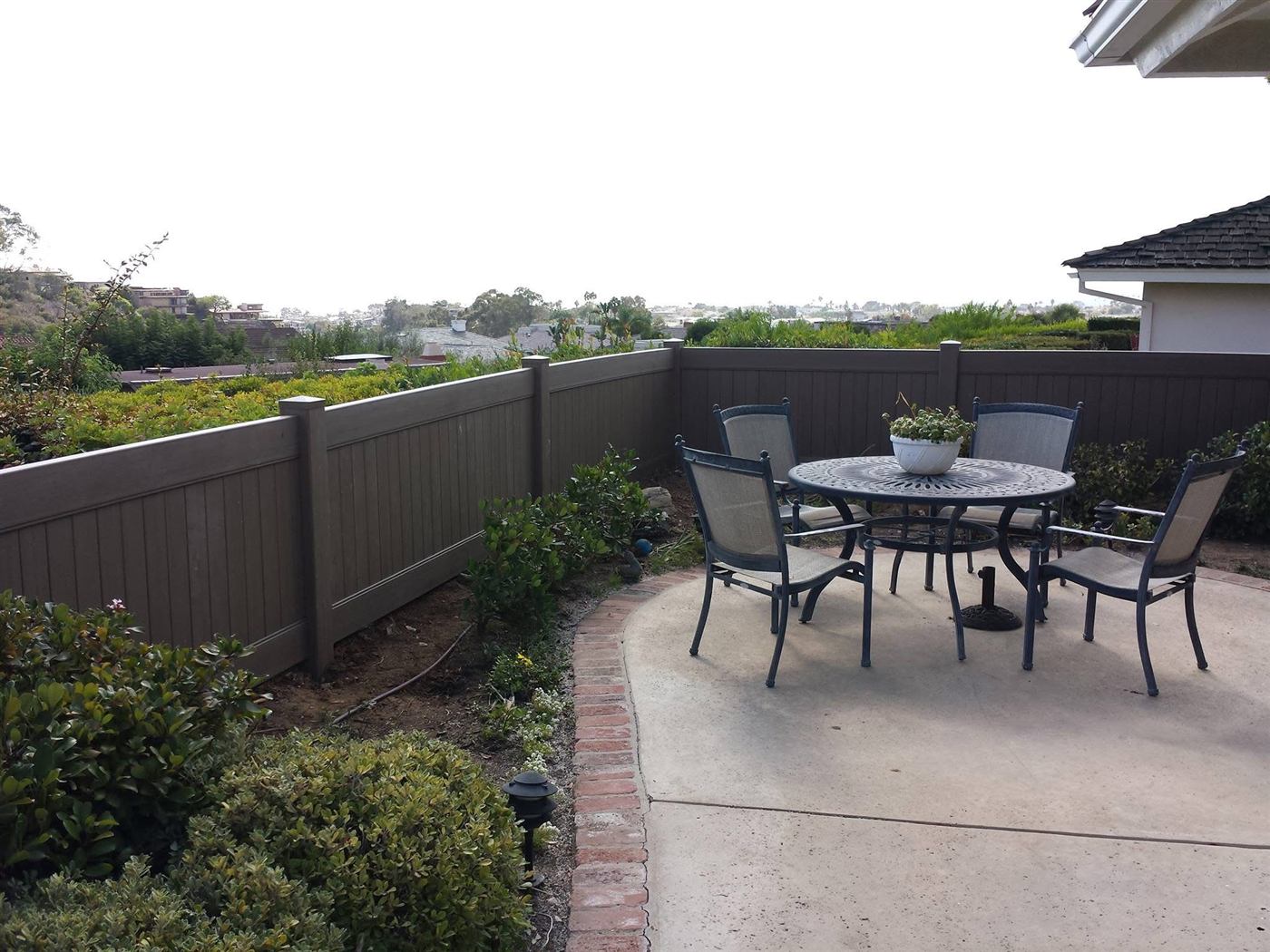 Vinyl privacy fence bordering a backyard garden